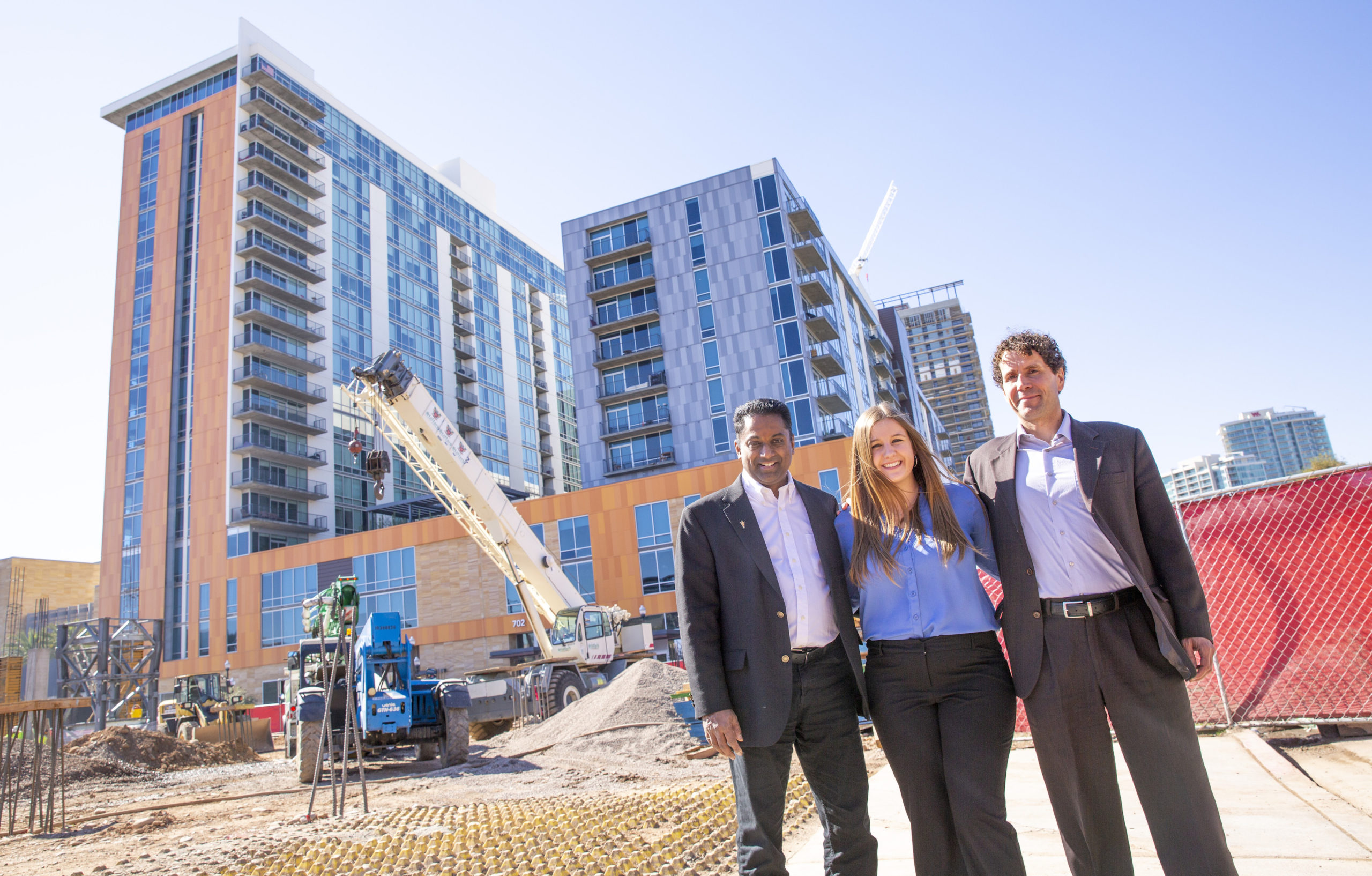 three people standing in front of construction site