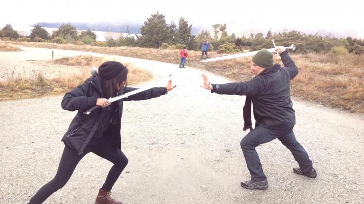 Two people play-fight with Tolkien-inspired swords.