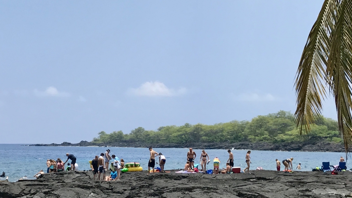 Tourists fill a Hawaiian beach.