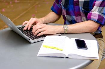 A person's hands on a laptop on a table