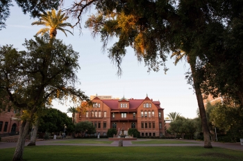 Picture of Old Main from far away with surrounding trees and greenery.