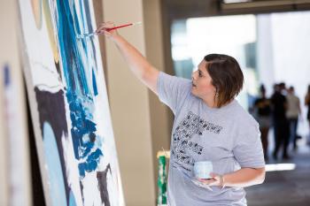 Photo of Heidi Hogden painting a mural at Herberger Institute Day