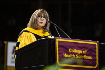 ASU College of Health Solutions Dean Deborah Helitzer speaks at a lectern at the May 2019 commencement