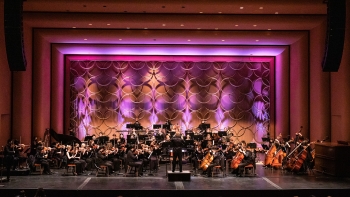 Orchestra playing on a stage.