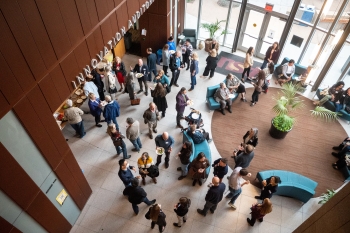Overhead view of a group of people mingling in the lobby below at the Edson College of Nursing and Health Innovation