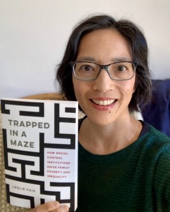 ASU sociology Professor Leslie Paik holding up a copy of her book "Trapped in a Maze: How Social Control Institutions Drive Family Poverty and Inequality"