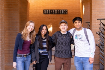Students in the School of Mathematical and Statistical Sciences smile outside Wexler Hall.