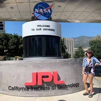 Adrienne stands outside next to the JPL welcome sign.
