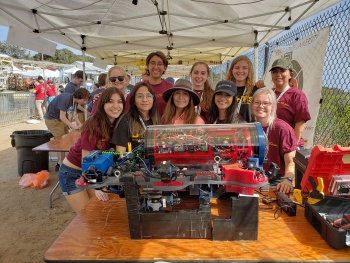 group of students posing with underwater robot