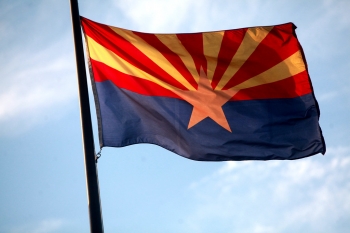Arizona State flag with a blue sky in the background