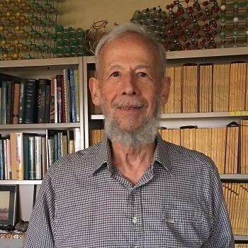 Headshot of Peter Buseck in front of a bookcase.