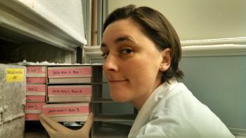 A scientist loads breast milk samples into a refrigerator