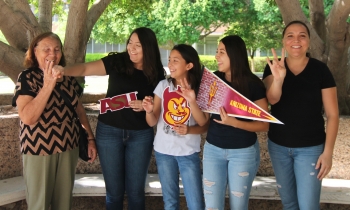 Family of a CAMP student posing for picture with ASU-themed signs.