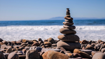Stock image: stacked stones with ocean in the background
