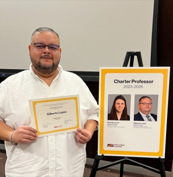 ASU Professor Gilberto Lopez holding a certificate for the Charter Professor Award.