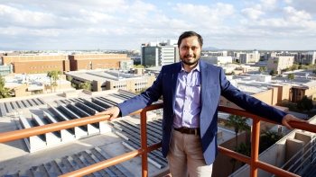ASU Assistant Professor Anamitra Pal on a rooftop overlooking solar panels.