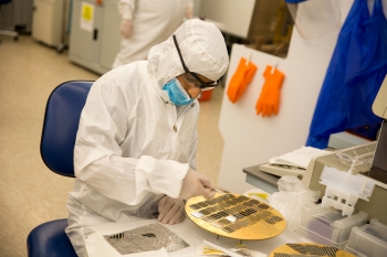 A researcher works with semiconductor materials in a lab.