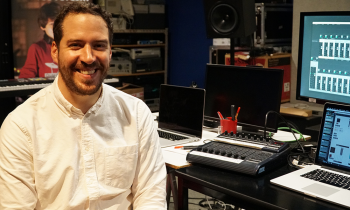 Le professeur adjoint de l'ASU, Gabriel José Bolaños, est assis et sourit dans un studio de musique.