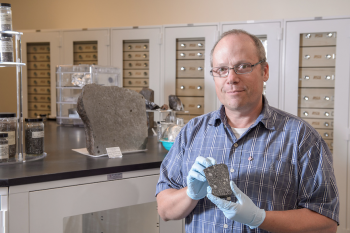 Professor Laurence Garvie holds meteorite.
