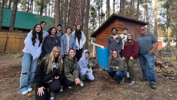 Students in the ASU chapter of Engineers Without Borders pose for a group photo while on a retreat in the woods.