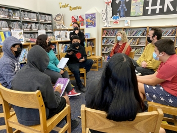 Emerson school students sitting in a circle in a library with ASU staff and faculty.