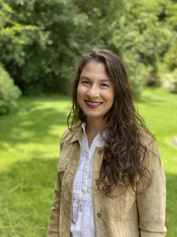 Portrait of ASU Professor Ayşe Çiftçi outside with a natural backdrop of green grass and leafy trees.