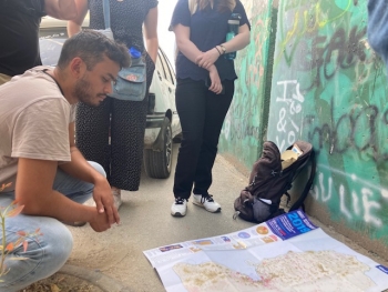 A young man looks at a map on the floor