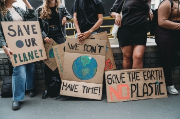 Protesters hold signs about the environment