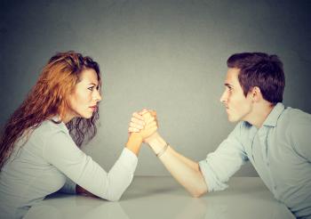 Woman and man arm wrestling