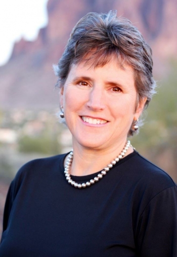Headshot of Jane L. Morris smiling at the camera with mountain scenery in the background.