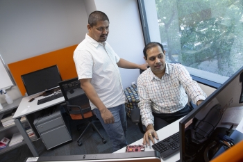 Two ASU researchers look at a computer.