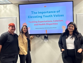 Manuel Elizalde, Wendy Ruiz, Kimberly Rios standing in front of a screen that reads "The importance of Elevating Youth Voices" with smaller text underneath