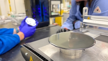 A wafer of semiconductor material sits on a table in a laboratory setting.