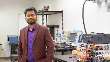 Ayan Mallik standing in a lab posing for a photo.