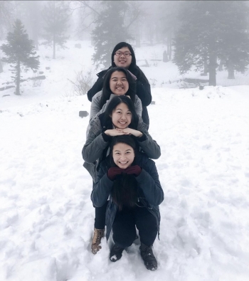 Nikki lines up with smiling friends on snowy landscape