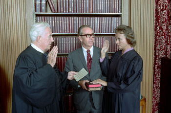 U.S. Justice Sandra Day O'Connor placing her hand on a Bible during her swearing-in ceremony.