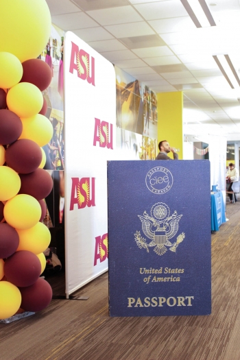 ASU Passport Caravan sign shown in a hallway with ASU-branded signage and balloons.