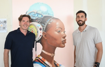 Artist James Angel and College of Health Solutions Professor Chad Stecher at Phoenix Bioscience Core art exhibition standing in front of an art piece depicting a woman's facial profile.