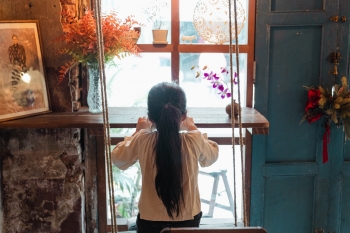 A child stares out a window.
