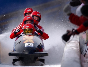 Four USA athletes in a bobsled at the 2002 Winter Olympics.