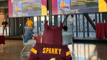 Sparky the Sun Devil watching students present during Ignite Sparky event