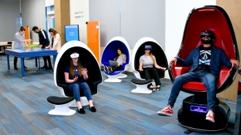 Students sitting in large chairs wearing VR headsets.