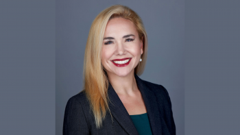 Rachele Peterson smiles at the camera in this professional headshot. She has blonde shoulder length hair. Is wearing a dark blazer and has bright red lipstick.