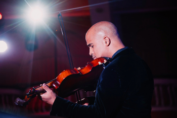 Daniel Bernard Roumain playing a violin.