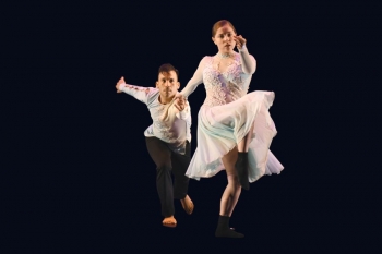 Two dancers perform a latin dance in costume.