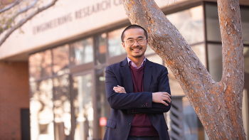 Houlong Zhuang posing in front of ASU's Engineering Research Center. 