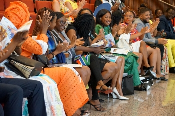 Group of people seated and clapping at an event.