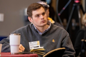 ASU student listening intently to a speaker at a School of Civic and Economic Thought and Leadership conference.