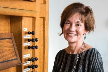 Kimberly Marshall, the Patricia and Leonard Goldman Endowed Professor of Organ in ASU's School of Music, Dance and Theatre, smiling while seated at an organ.