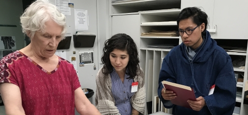 ASU-LACMA Fellows Ariana Enriquez and Matthew Villar Miranda work with Janice Schopfer, senior paper conservator in LACMA's Conservation Lab.